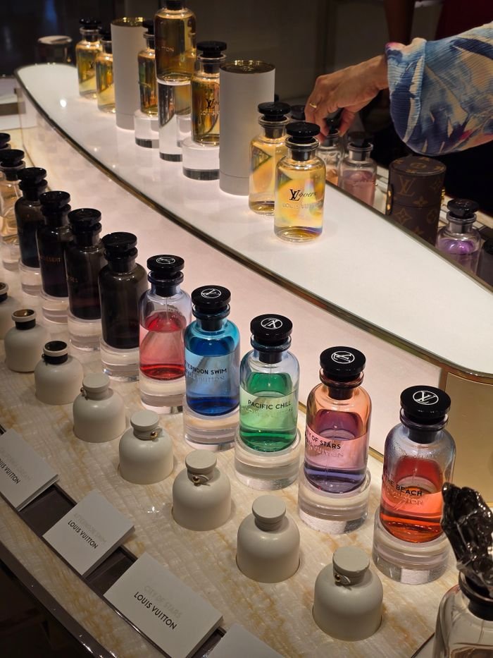 A vibrant display of luxury perfume bottles in various colors and fragrances.