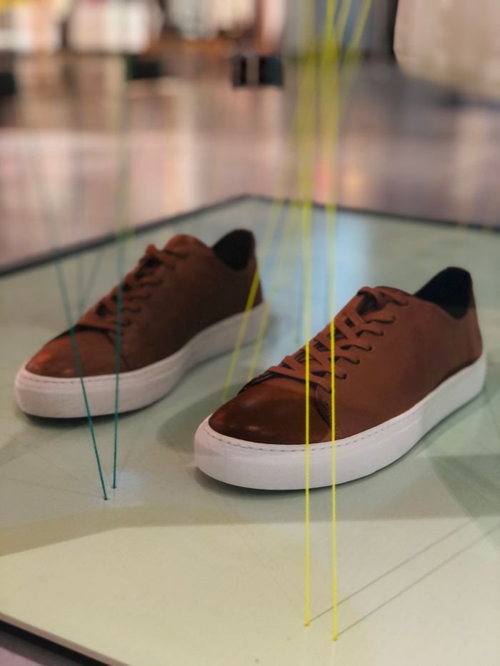 Elegant brown sneakers showcased stylishly indoors, perfect for fashion enthusiasts.